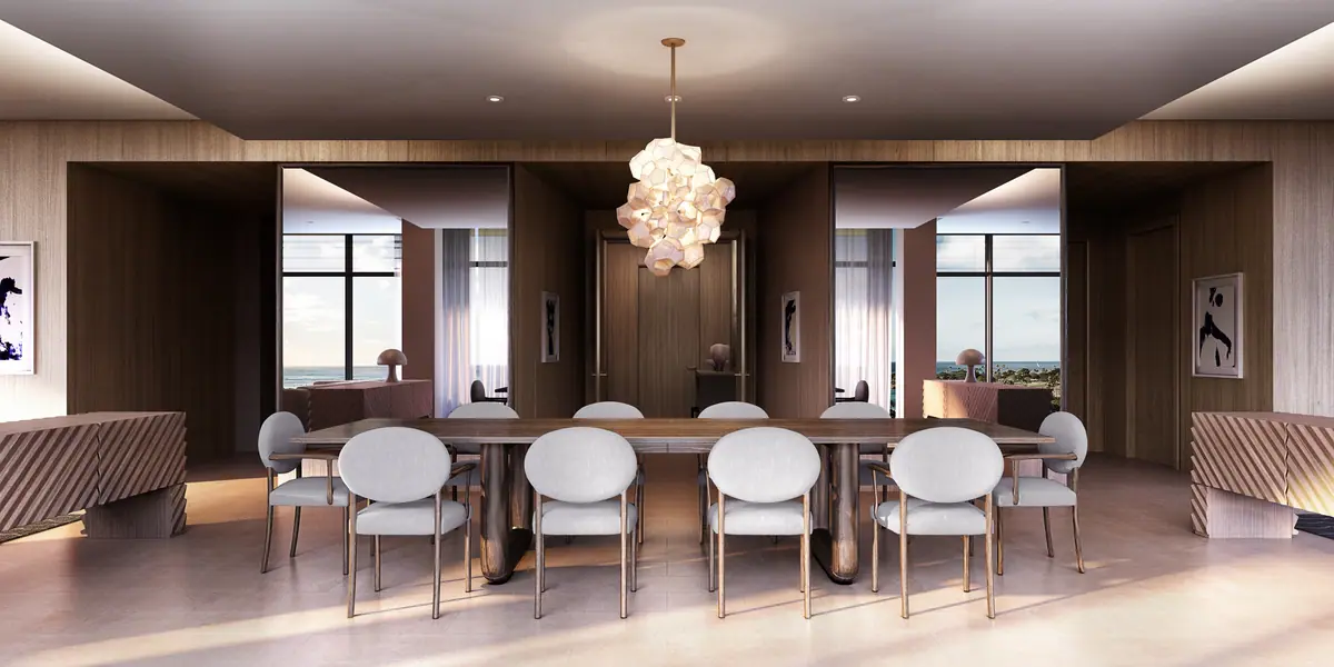 Dining room with a long table, white chairs and glass chandelier